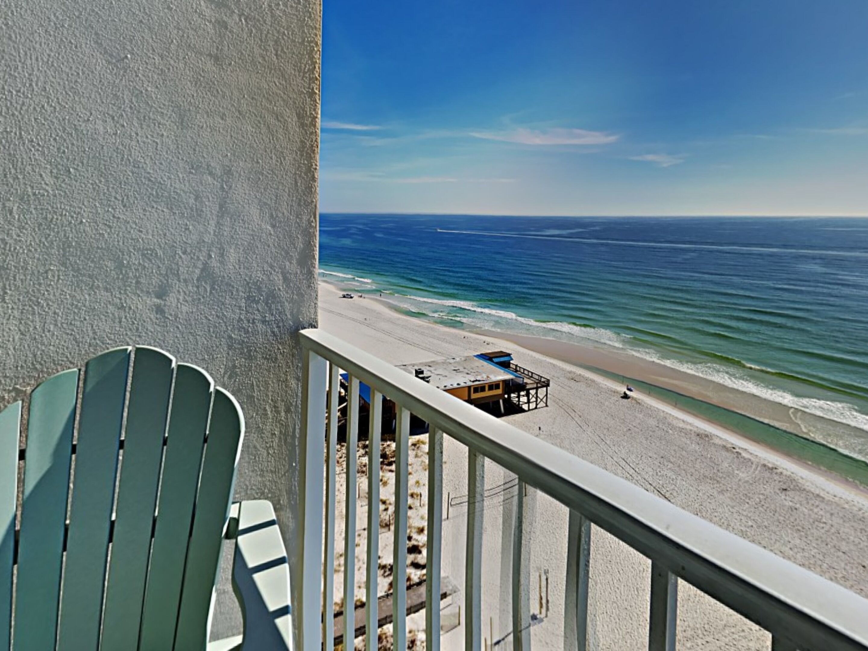 A balcony with a view of a beach and ocean.