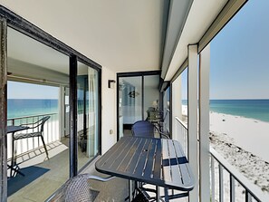 Relax on the balcony with a table and chairs, taking in the ocean and beach views.