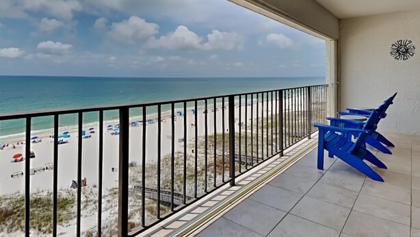 Un balcon avec vue sur une plage et l’océan.