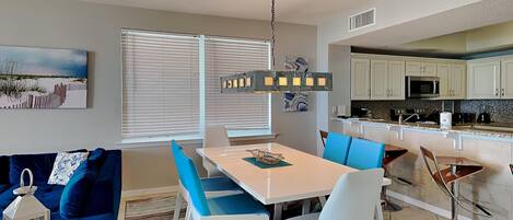A modern kitchen with white cabinets, a microwave, and a coffee maker.