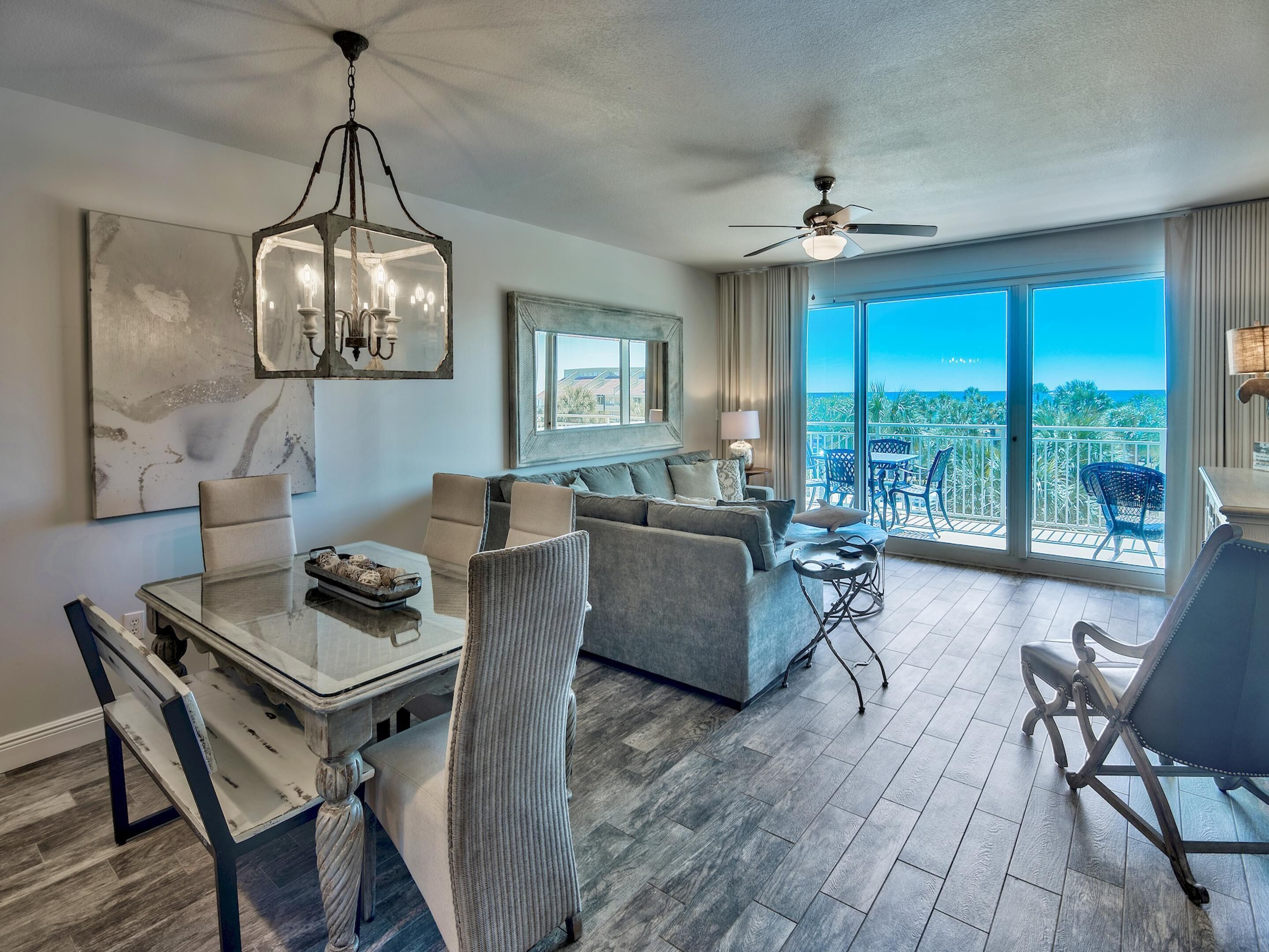 A spacious living area with a balcony, a dining table, and a sofa.