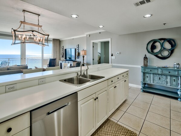 A modern kitchen with a large island, stainless steel appliances, and a view of the ocean. - Sterling Shores by Southern Vacation Rentals (Destin)