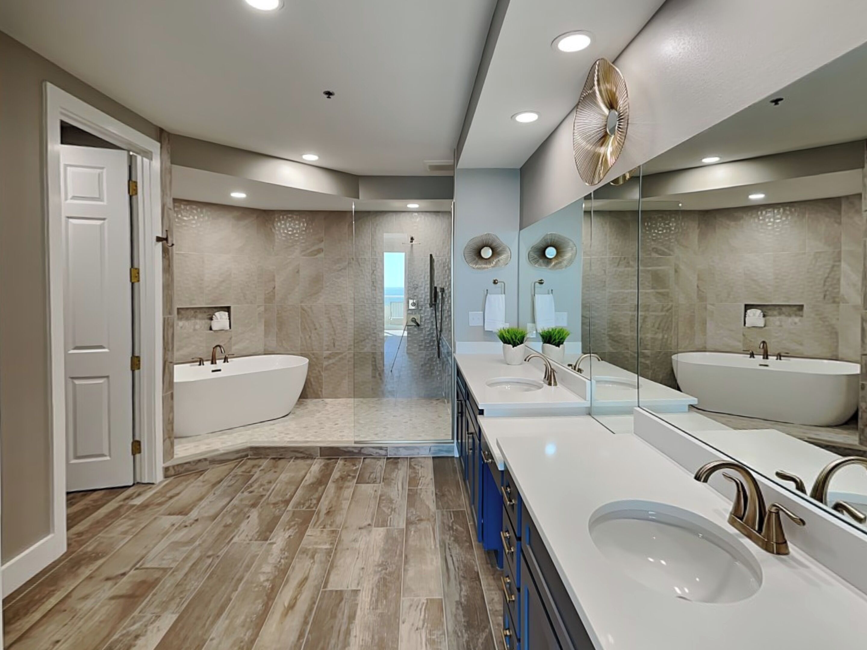 A modern bathroom with two sinks, a large bathtub, and a walk-in shower.