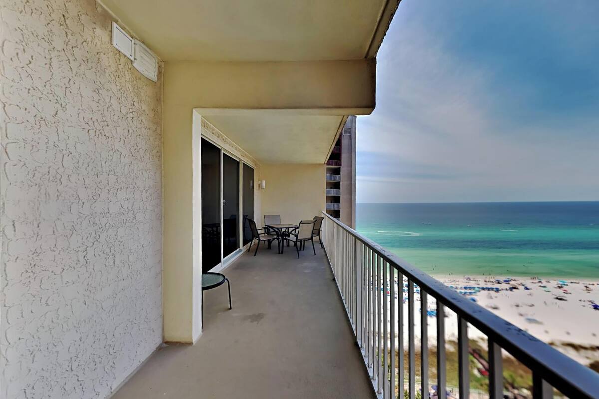 A balcony with a view of the beach and ocean.