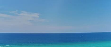 A beach with clear turquoise water and a sandy shore.