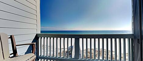 A wooden deck with a view of the ocean.