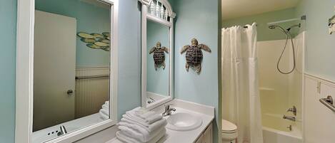 A bathroom with two sinks, a toilet, a shower, and a large mirror.
