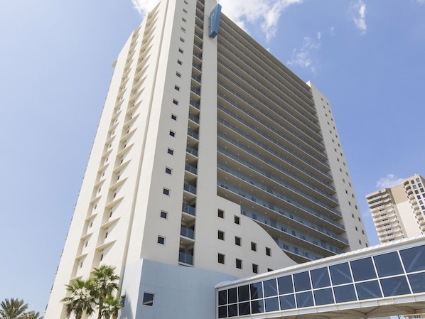 A tall, modern hotel with multiple floors and balconies.