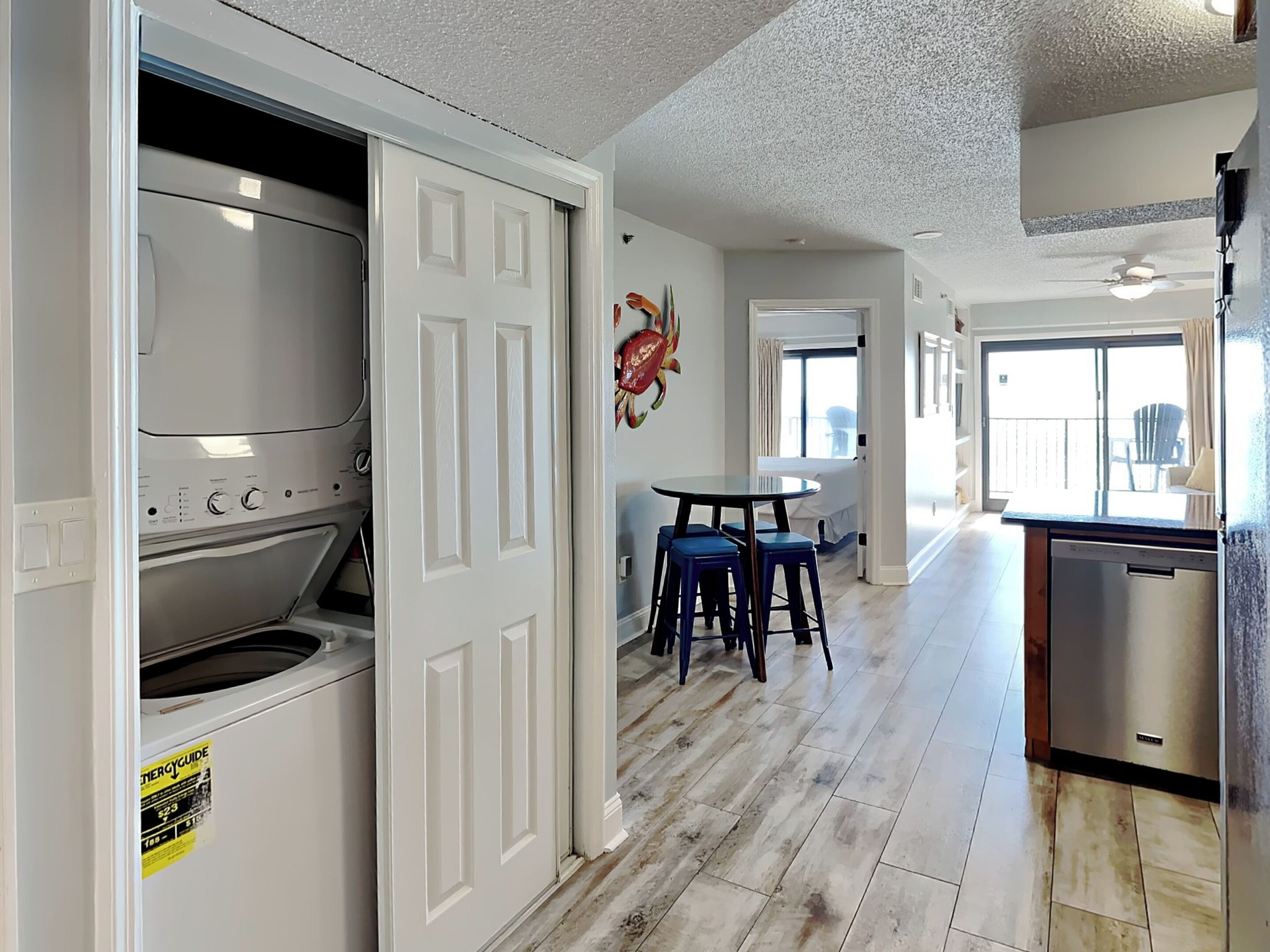 A kitchen with a built-in oven, a dining area with stools, and a view of the balcony.