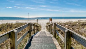 A wooden boardwalk leading to a beach with a clear sky. - Silver Beach by Southern Vacation Rentals (Orange Beach)