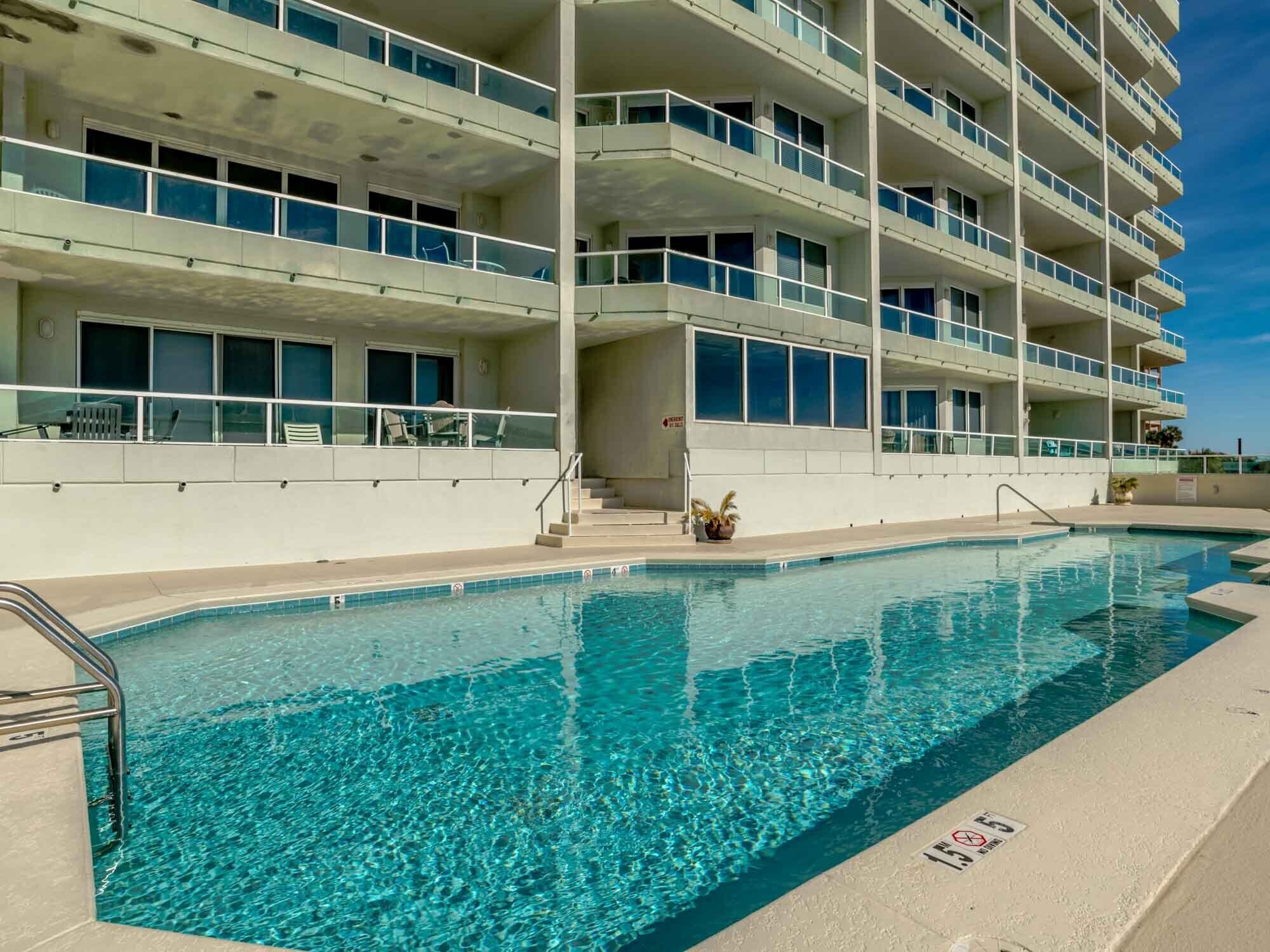 A multi-story hotel with a swimming pool.