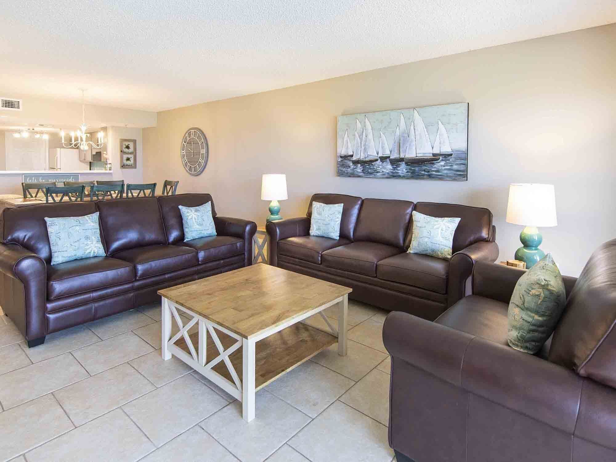 A living room with two brown leather sofas, a wooden coffee table, and two lamps.