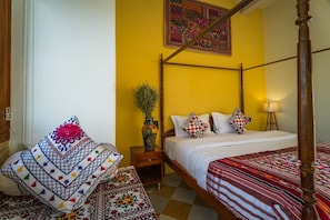 A four-poster bed with a wooden frame, a bedside table with a vase, and a patterned cushion. - Wild Heritage Desert Camp Jaisalmer (Jaisalmer)