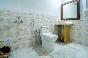 Un bagno con il water, doccia, lavandino e specchio.