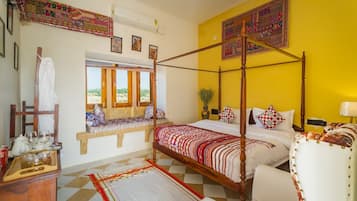A four-poster bed with a checkered floor, a bench with cushions, and a window with a view.