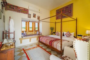 Una cama con dosel sobre un piso a cuadros, un banco con cojines y una ventana con vistas.