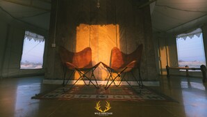 A tented room with a large window, two chairs, and a rug. - Wild Heritage Desert Camp Jaisalmer (Jaisalmer)
