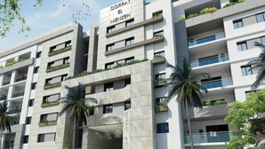 A modern multi-story building with balconies and a sign reading "DORRA EL MENZHEH". - 1 Bed Flat - Sleeps 2 - Parking - Wifi (Tunis)