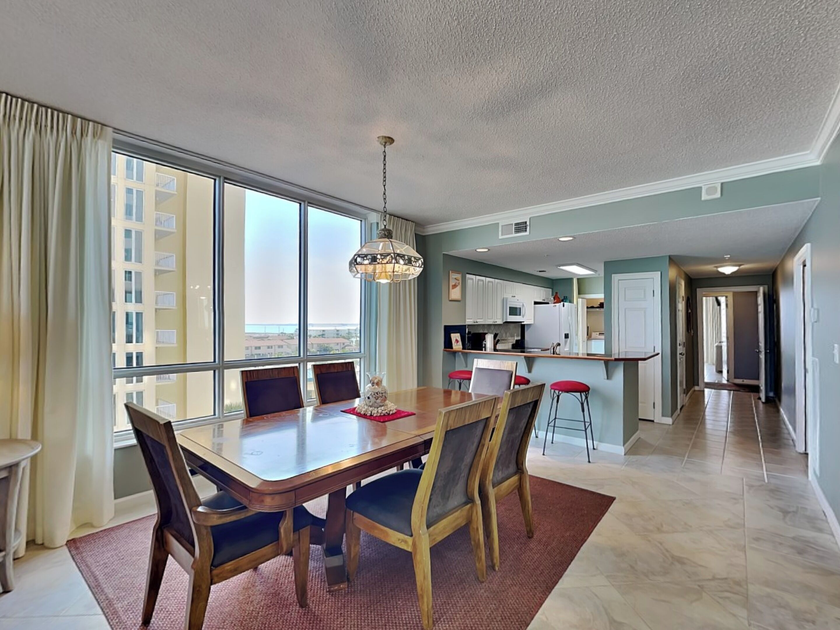 A dining area with a table, chairs, and a chandelier.