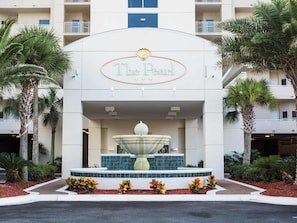 A hotel entrance with a large fountain, palm trees, and a sign reading 'The Pearl.' - The Pearl of Navarre by Southern Vacation Rentals (Navarre)