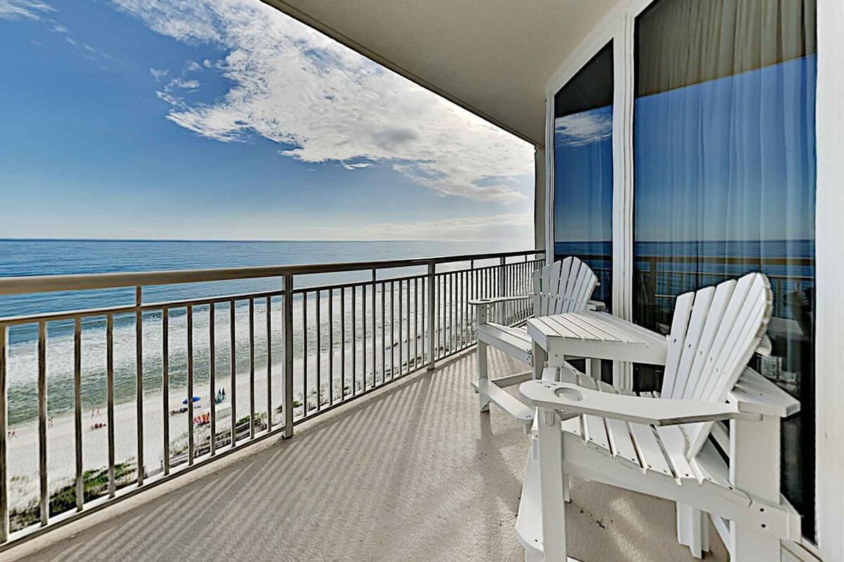 A balcony with a view of the beach and ocean.