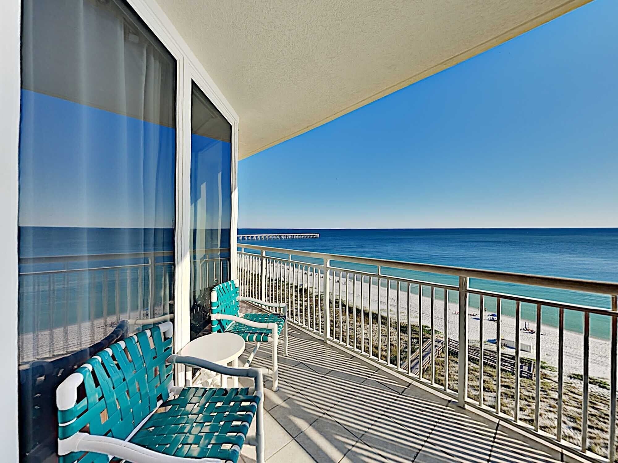 A balcony with a view of the beach and ocean.