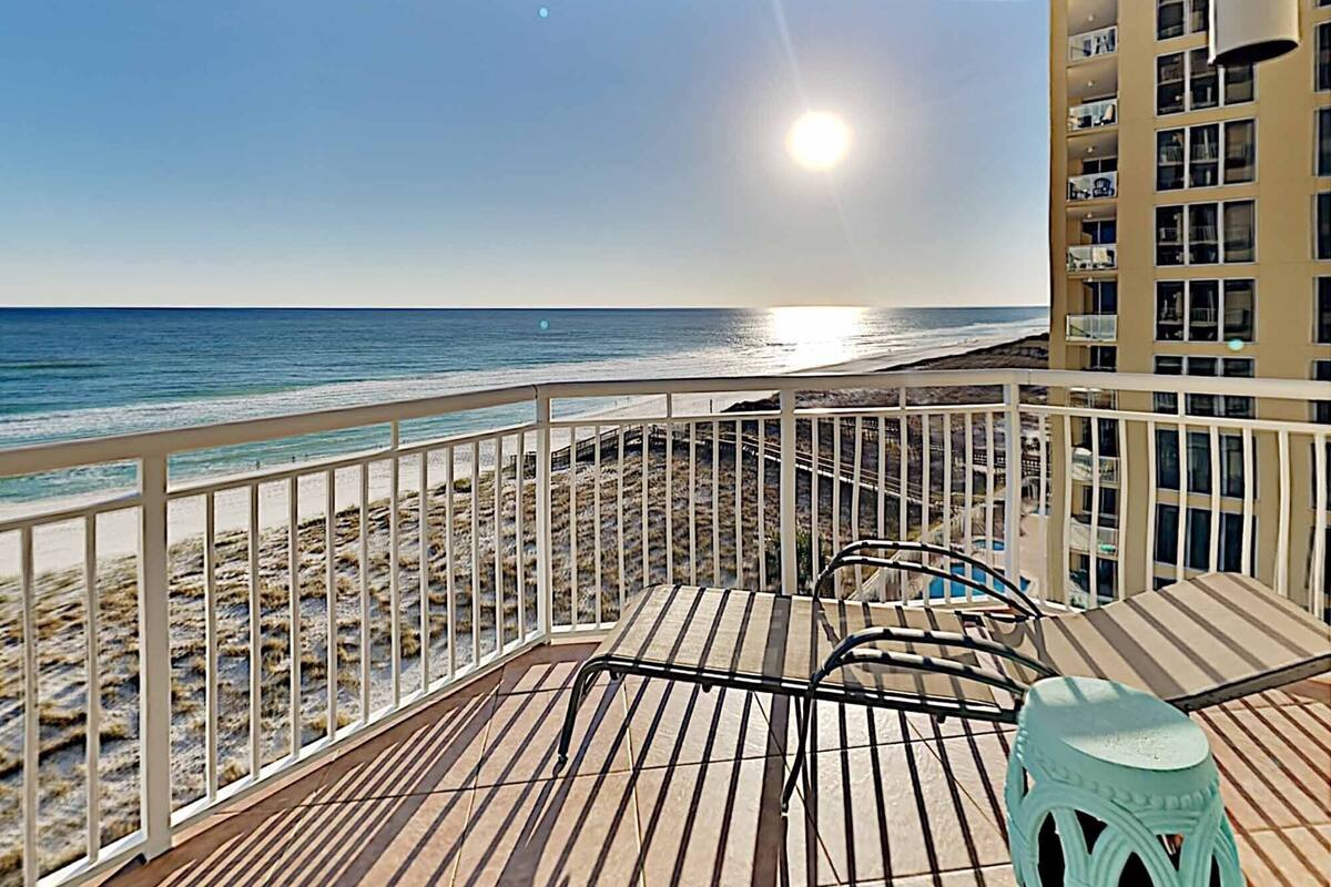 A balcony with a view of the beach and ocean.