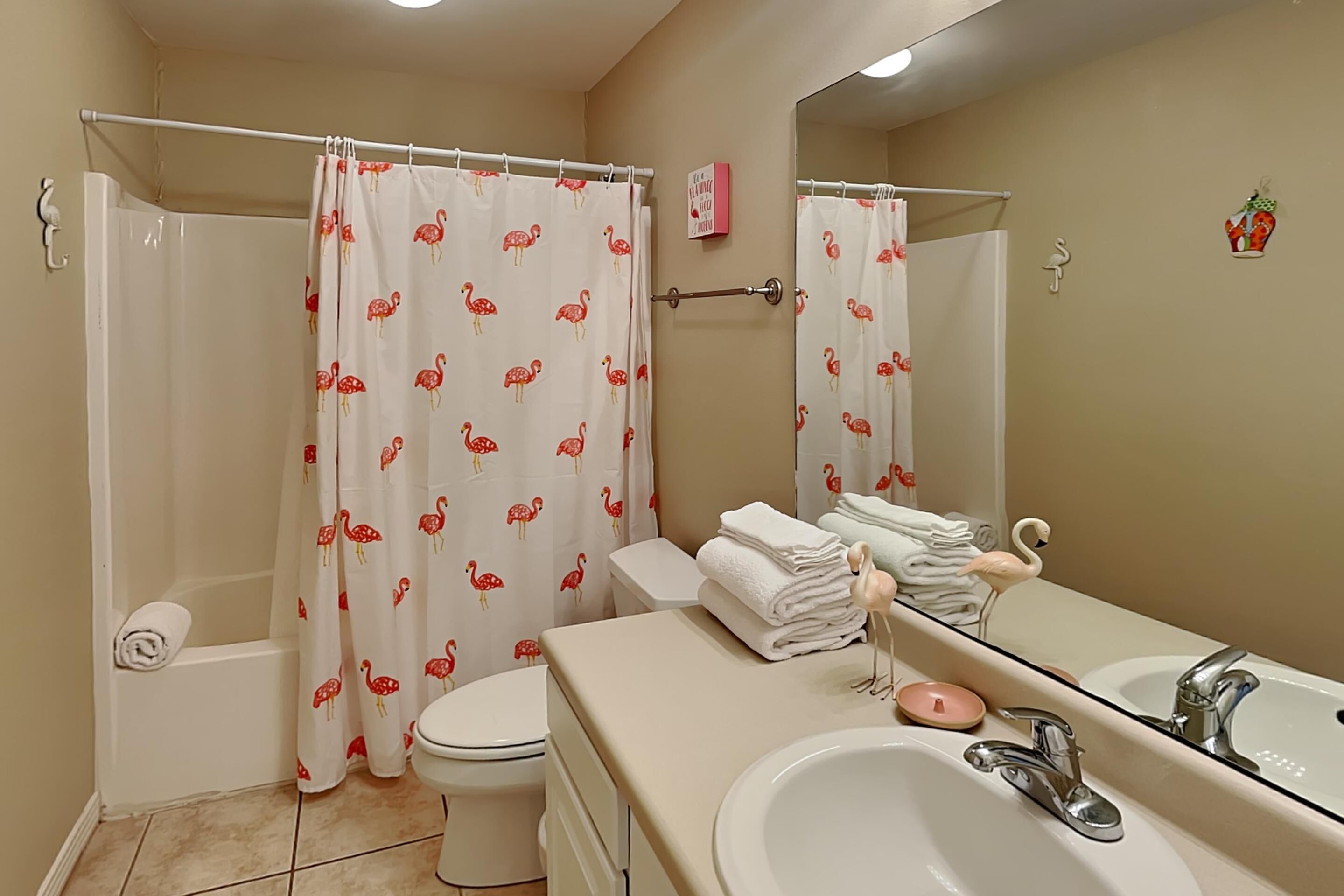 A bathroom with a shower, toilet, and sink.