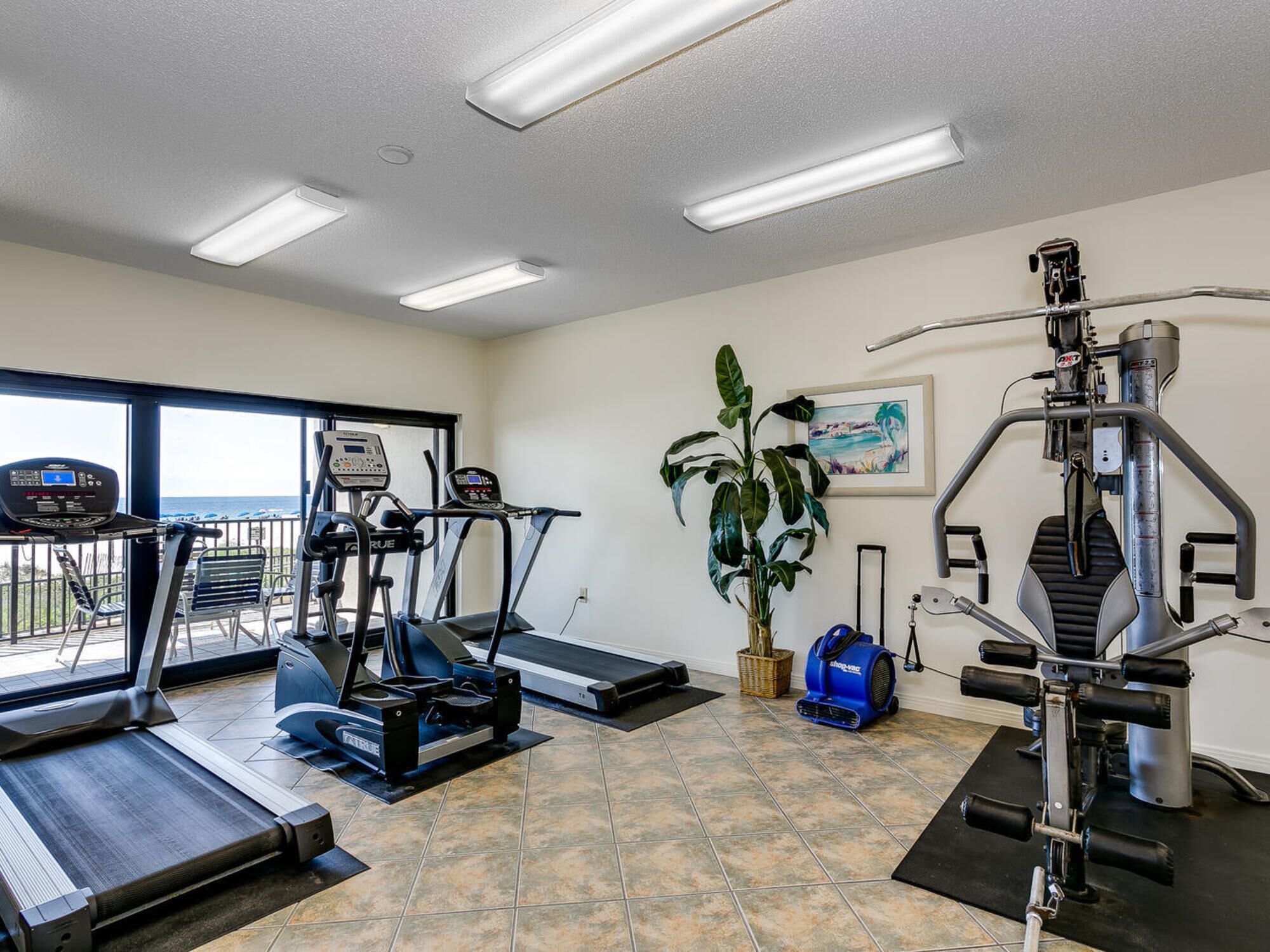 Et fitnesscenter med løbebånd, en motionscykel og et vægttræningsapparat.