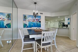 A dining area with a table, chairs, and artwork on the walls. - The Palms of Orange Beach by Southern Vacation Rentals (Orange Beach)