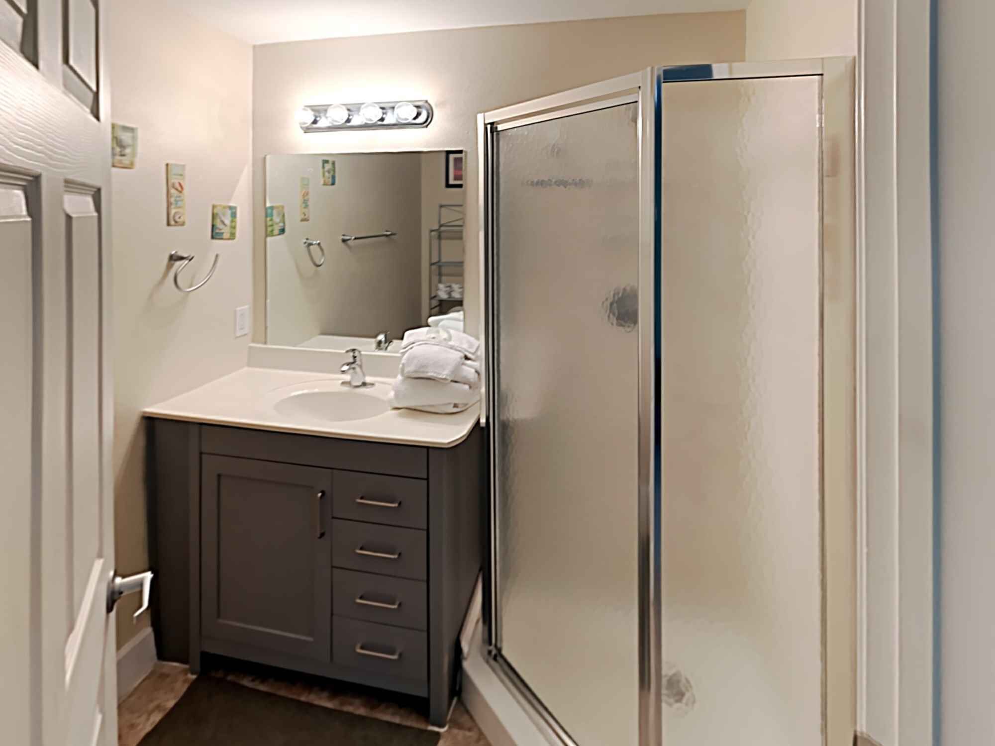 A bathroom with a vanity, sink, and mirror.