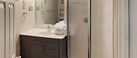 A bathroom with a vanity, sink, and mirror.