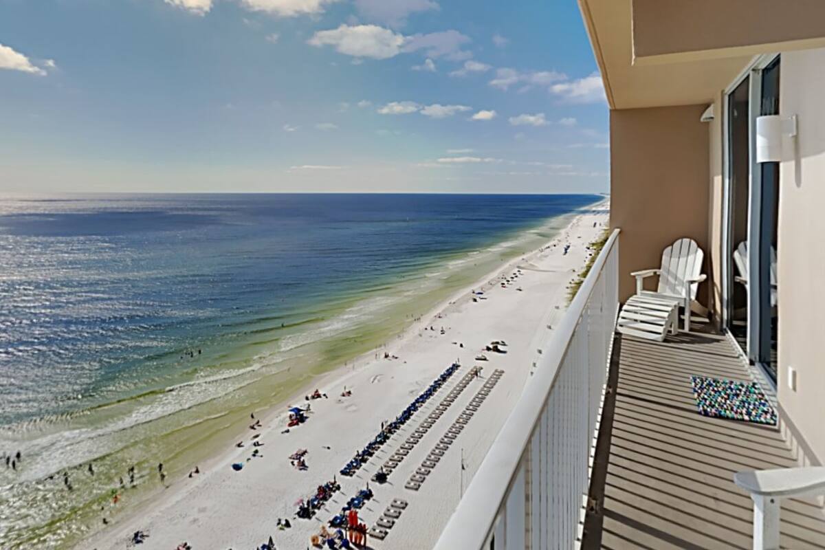 A balcony with a view of a beach and ocean.