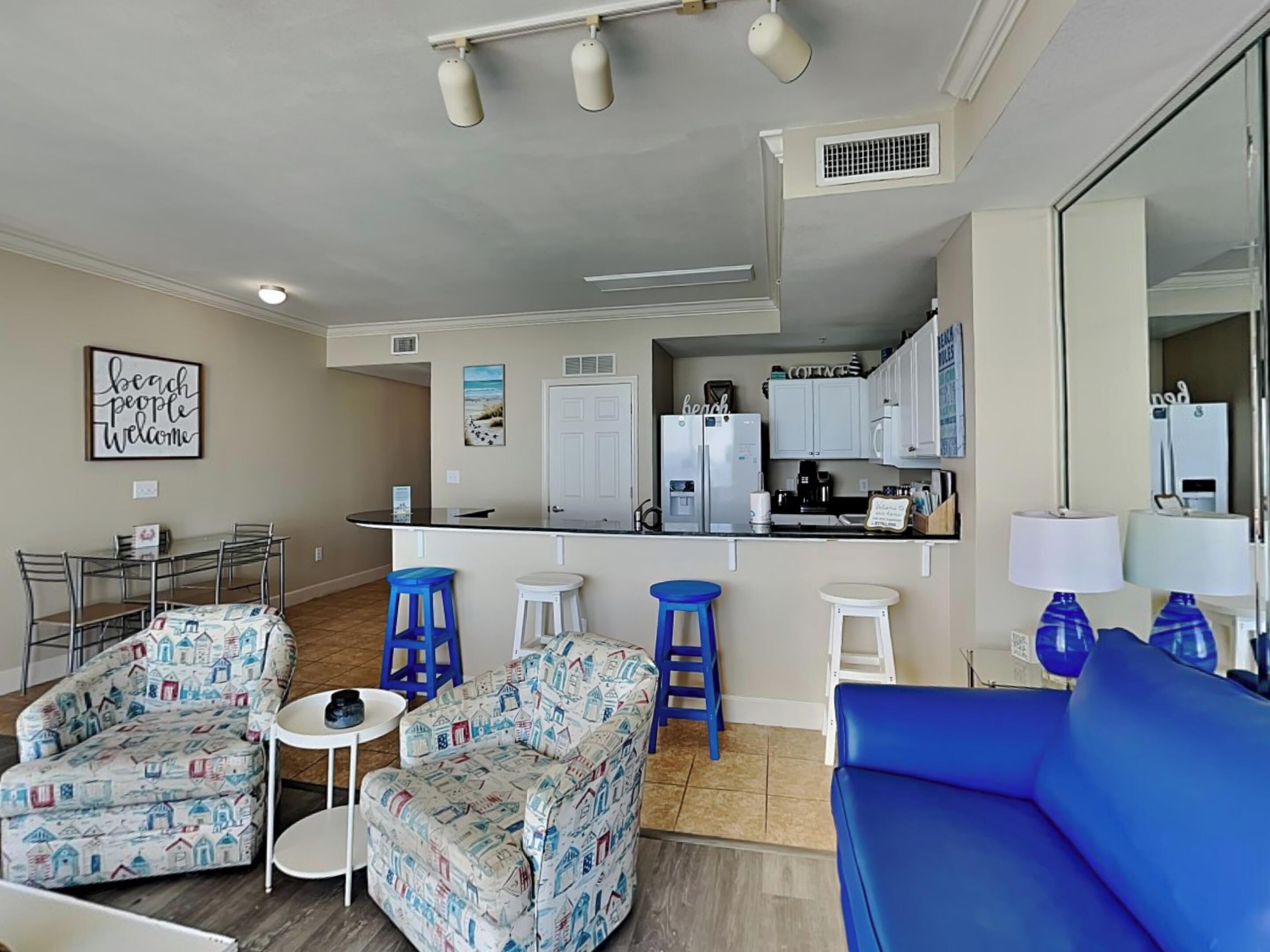 A compact living space with a kitchenette, a dining area, and a seating area with patterned furniture.