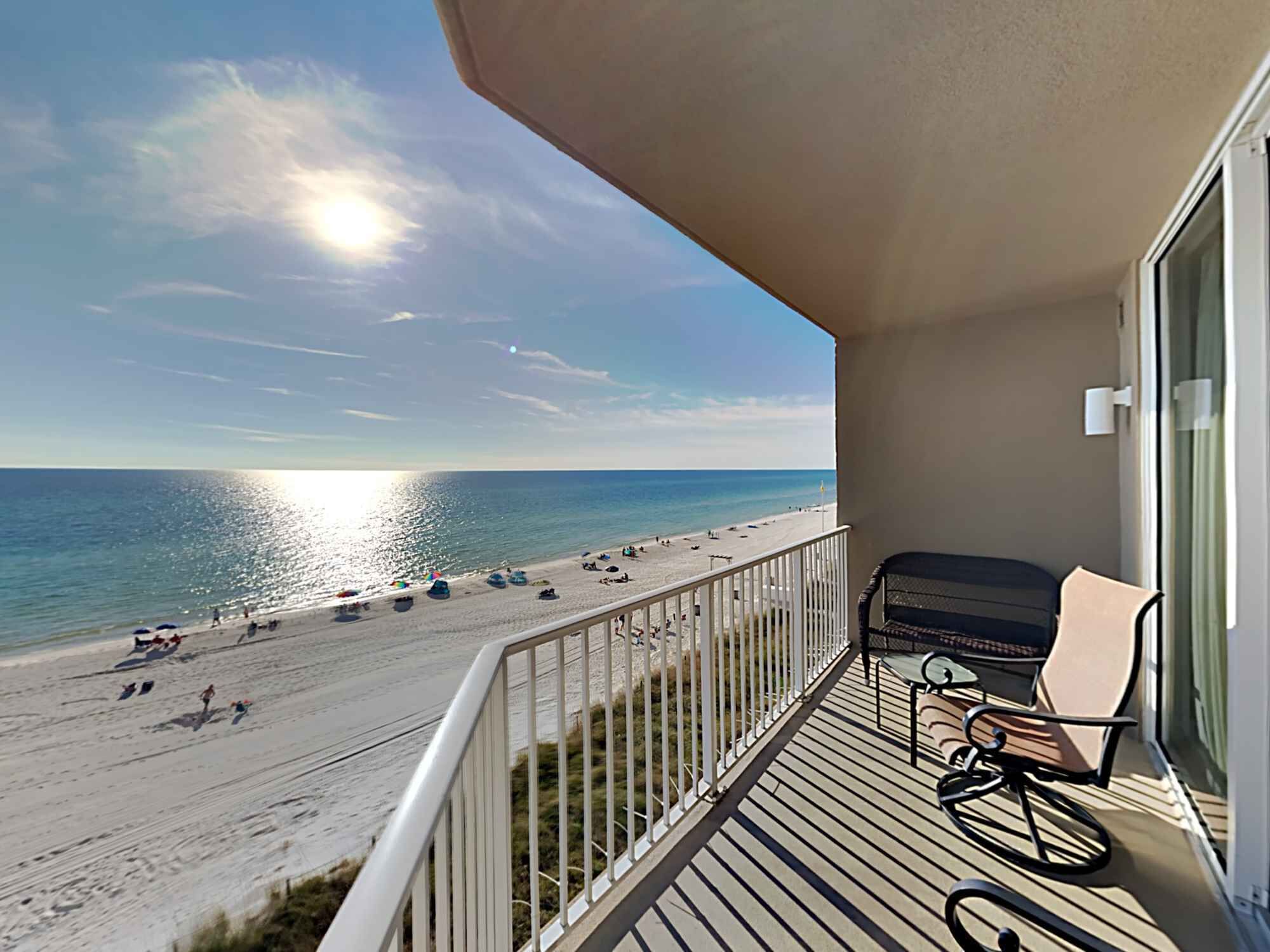 Un balcon avec vue sur une plage et l’océan.