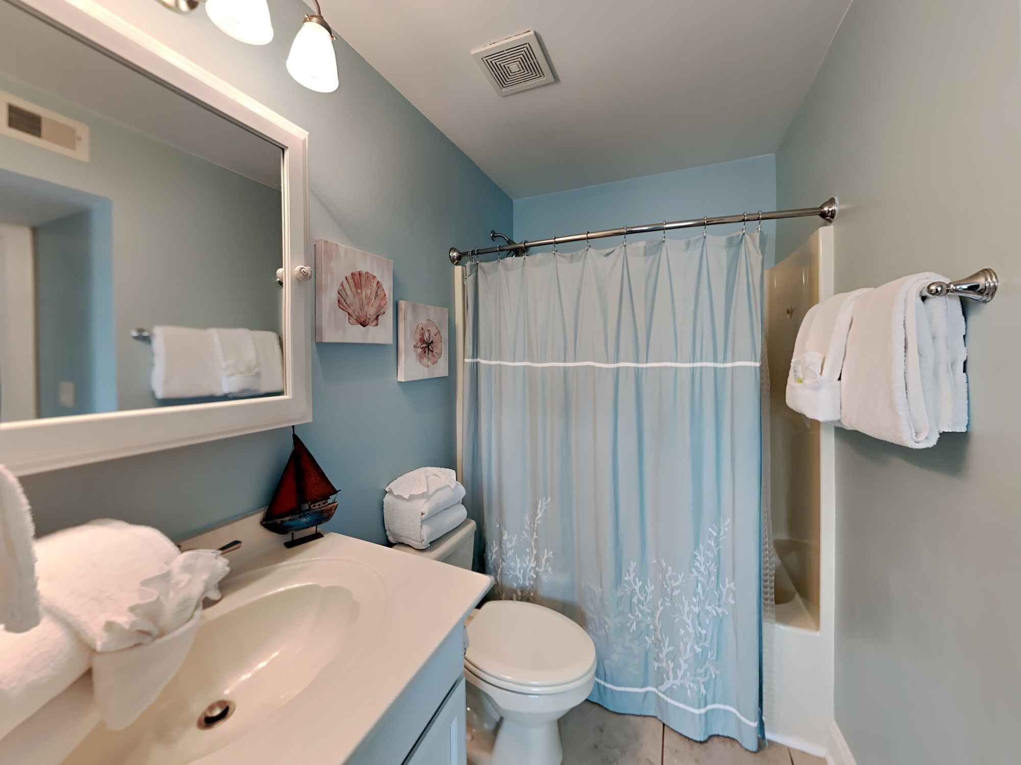 A bathroom with a sink, toilet, and shower curtain.
