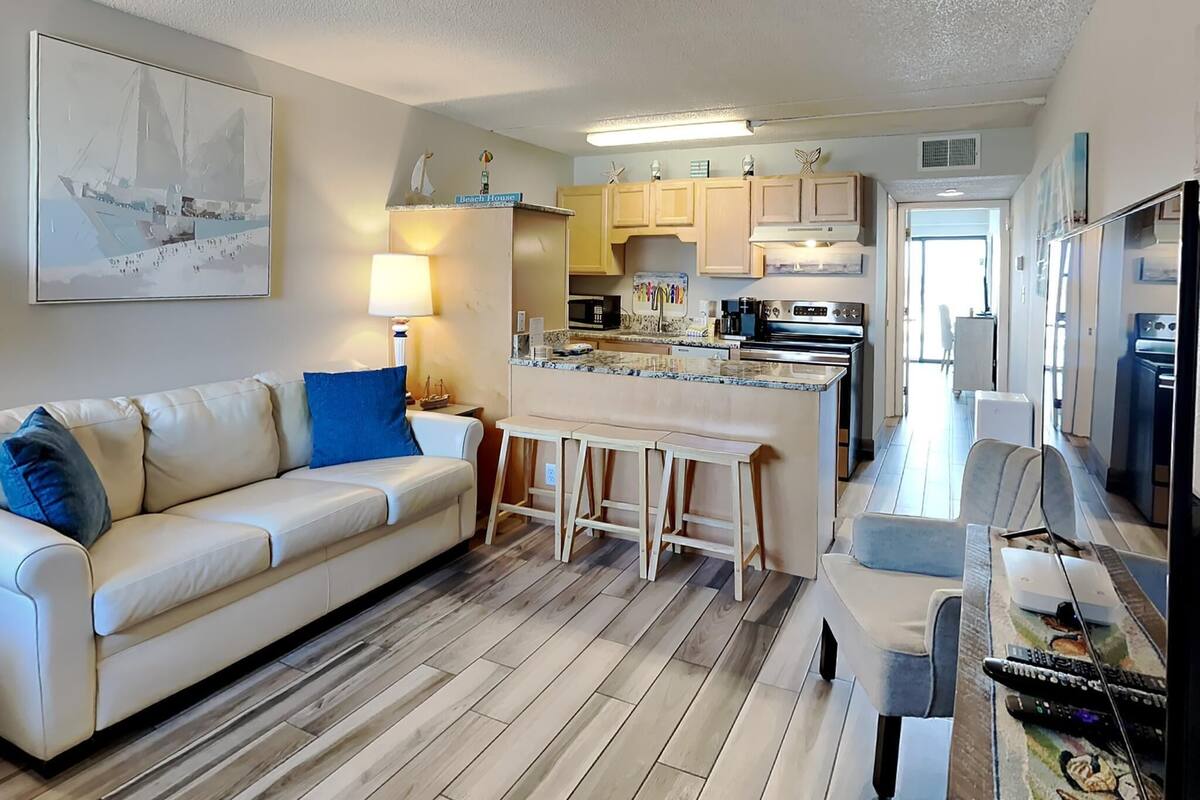 A modern apartment with a living room, kitchen, and dining area.