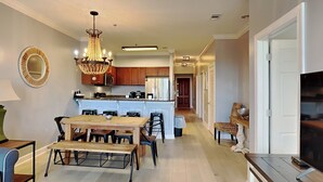 A spacious kitchen with wooden cabinets, a central island, and a chandelier.