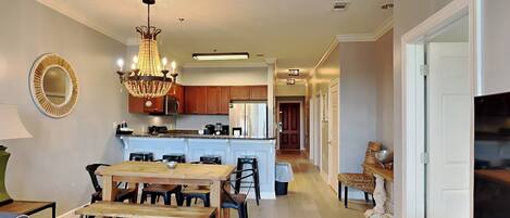 A spacious kitchen with wooden cabinets, a central island, and a chandelier.