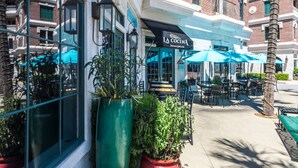 A restaurant with outdoor seating, a large planter, and a sign reading "LA COCINA Mexican Grill & Bar".