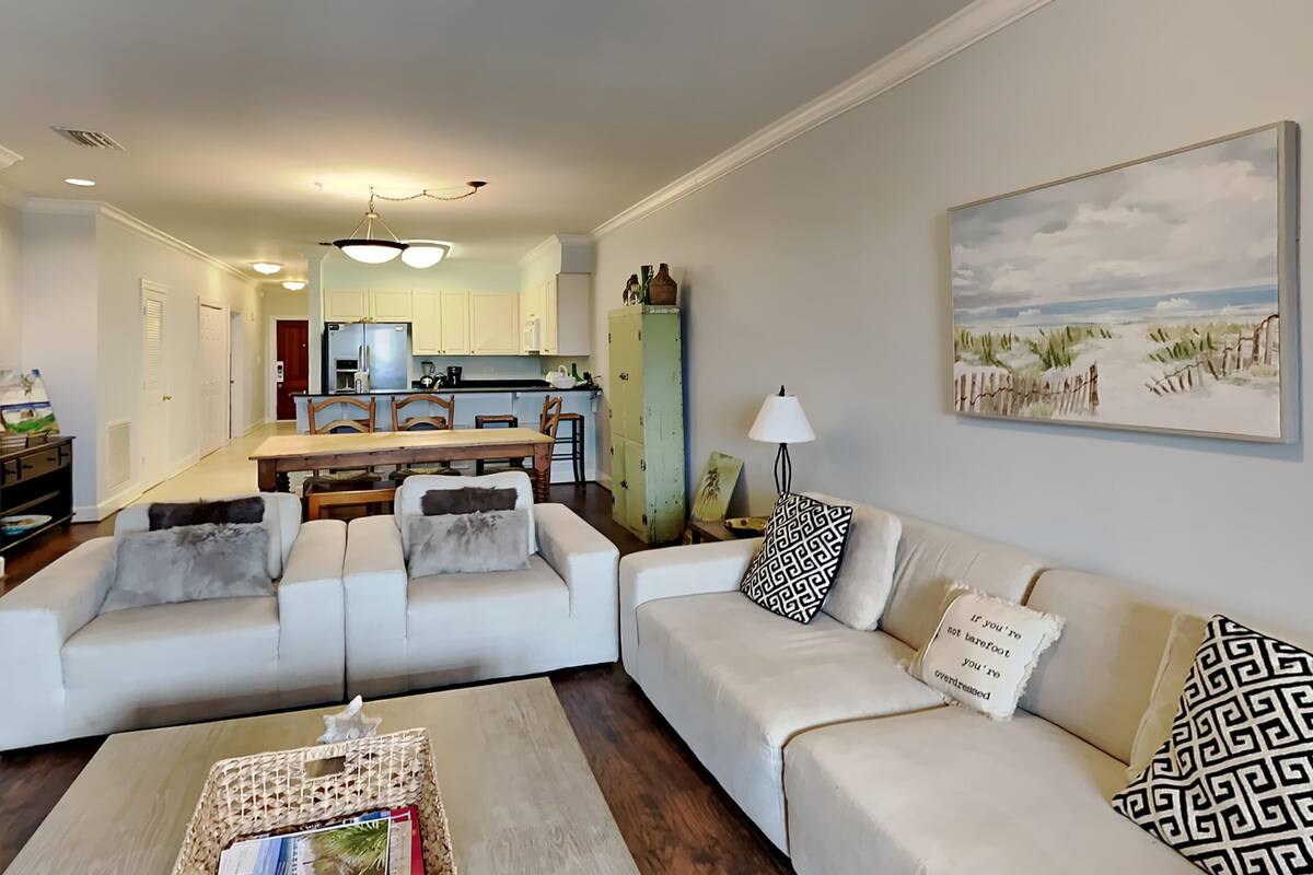 A living room with a sofa, coffee table, and a painting on the wall.
