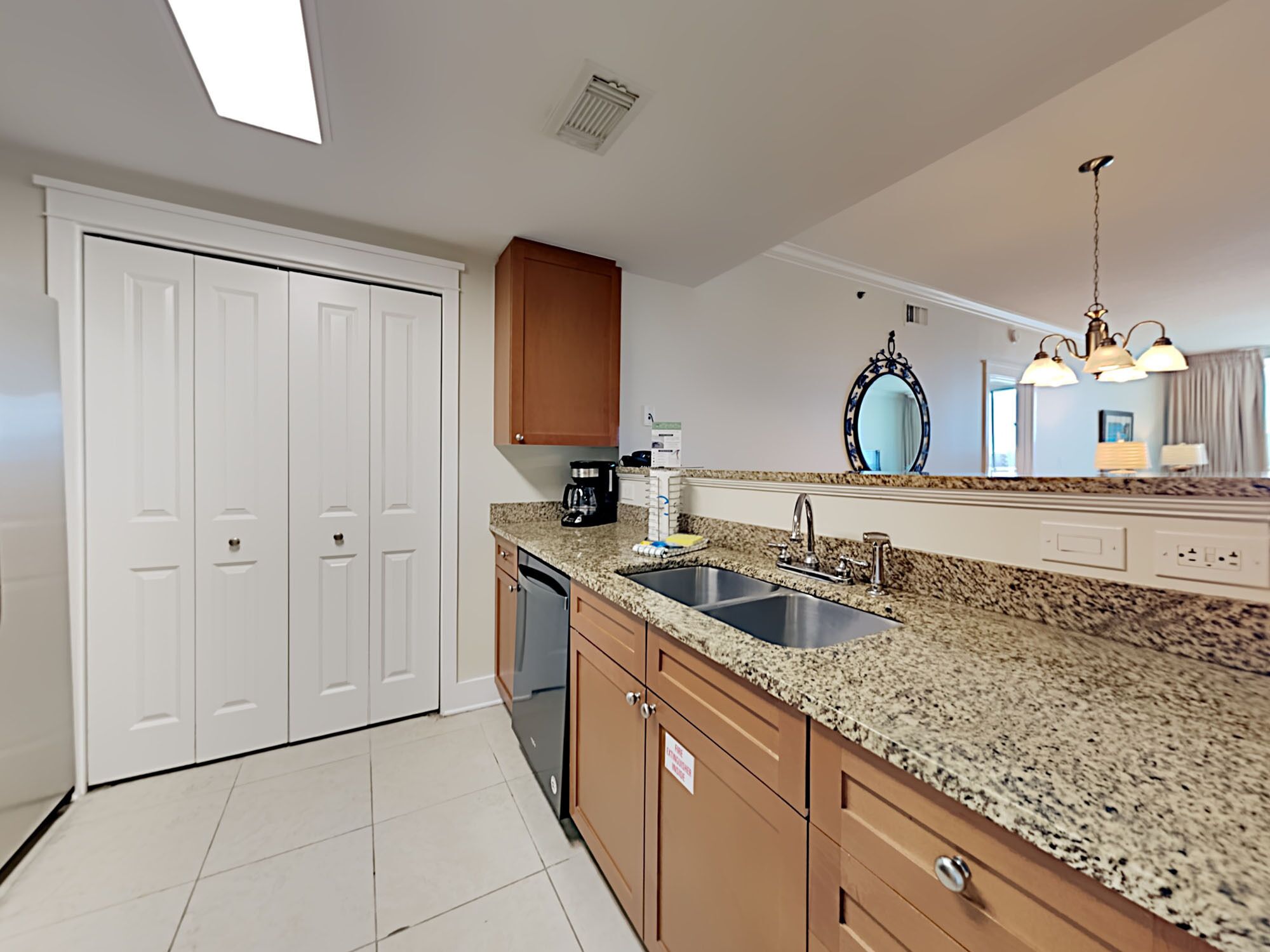 A modern kitchen with granite countertops, a double sink, and wooden cabinets.