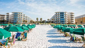 A beach with rows of beach chairs and umbrellas, a sandy path, and multi-story buildings in the background. - Waterscape by Southern Vacation Rentals (Fort Walton Beach)