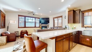 Enjoy cooking and dining in this well-equipped kitchen with a central island, stove, and stainless steel sink.