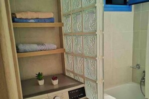 A bathroom with a wooden shelf, a small plant, and a decorative wall panel. - 1 Bed Apt - Sleeps 2 - Free Parking - Sea View (Kalymnos)