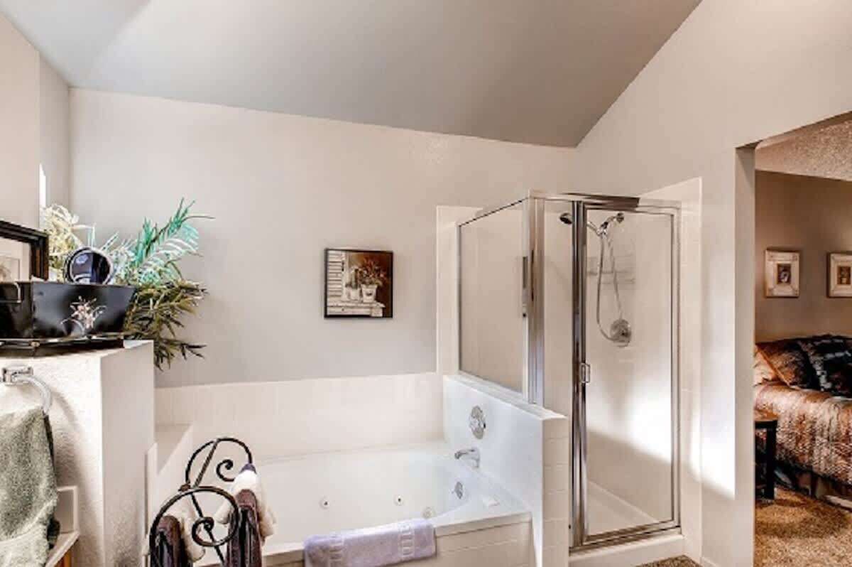 A bathroom with a bathtub, shower, and a small sink.