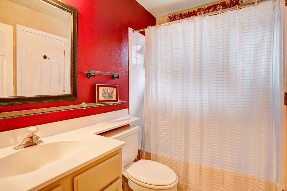 A bathroom with a white sink, a toilet, and a shower curtain.