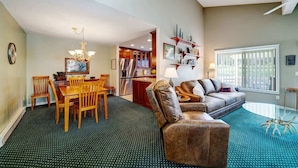 A spacious living area with a dining table, leather sofa, and a glass coffee table. - Peace on the Pond - 70 Pond (Blairsden)