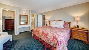A hotel room with a large bed, a dresser, a mirror, and a door leading to another room. - Peace on the Pond - 70 Pond (Blairsden)