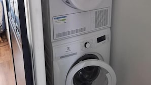 A front-loading washing machine and dryer stacked vertically in a laundry room. - Turpault vue mer port maria quiberon 2* (Quiberon)
